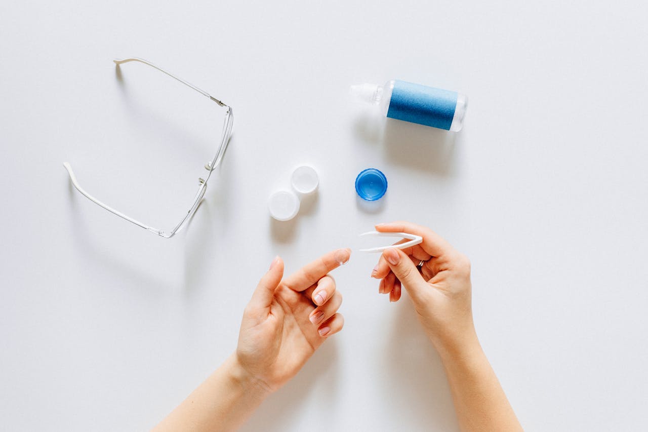 The Art of Drawing Readers In: Your attractive post title goes here Top view of contact lens tools and glasses on a white surface.